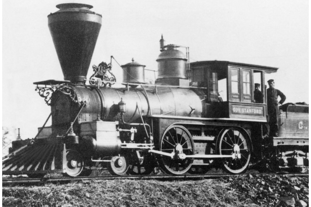 Early steam train with conductors on board.
