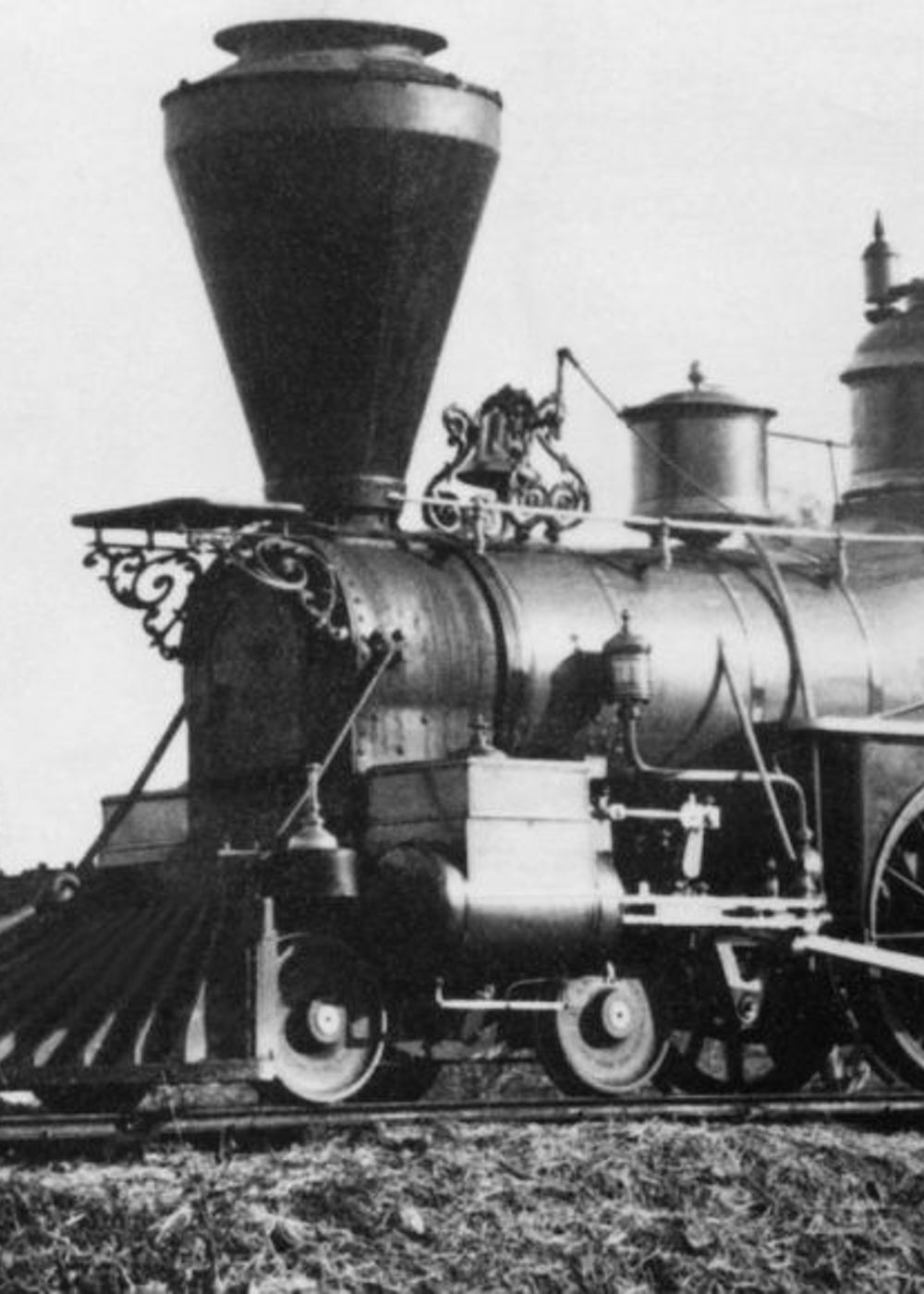 Early steam train with conductors on board.